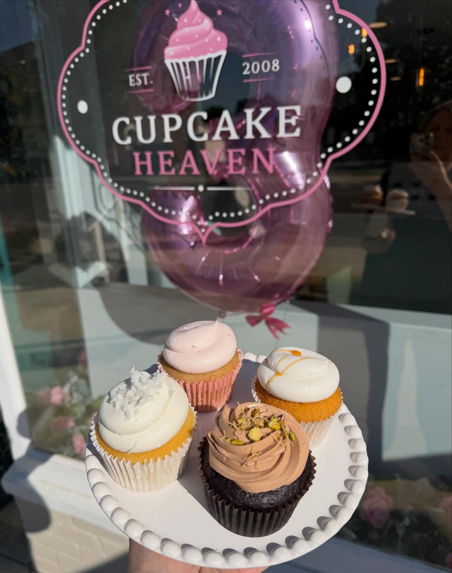 Cupcake Heaven storefront with celebratory balloon and assorted cupcakes